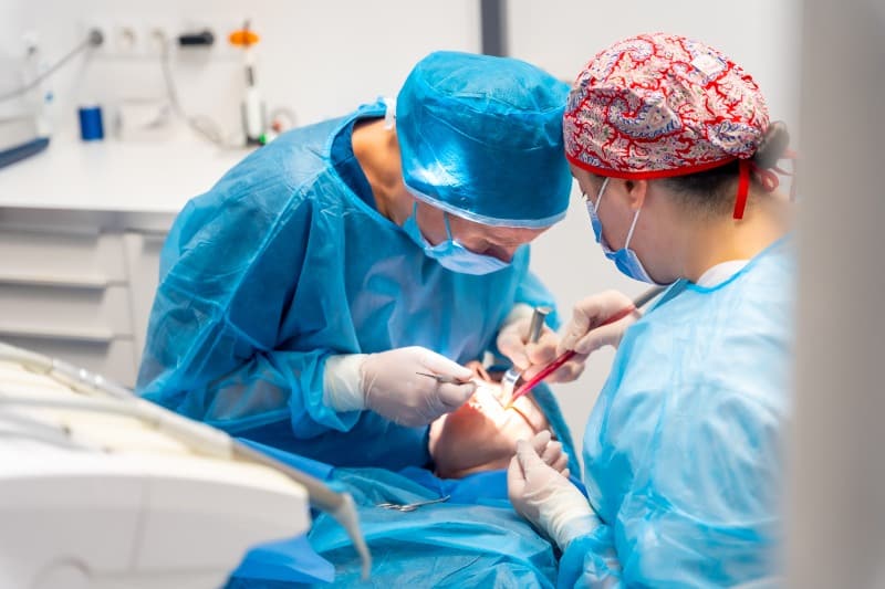 Dental clinic with dentist and assistant performing an oral operation on a client in Austin, TX